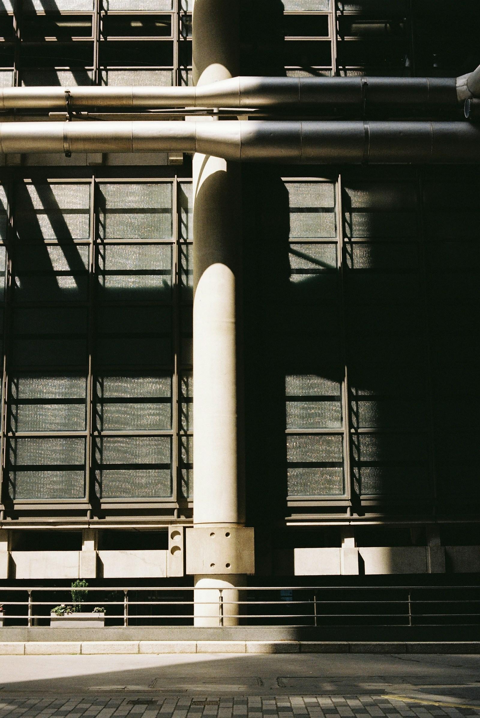 Industrial facade with exposed pipes and geometric shadows